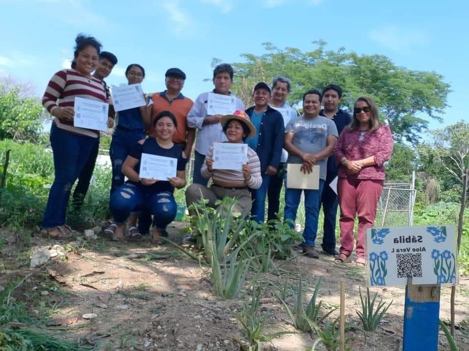 Participantes mostrando constancias en proyecto comunitario